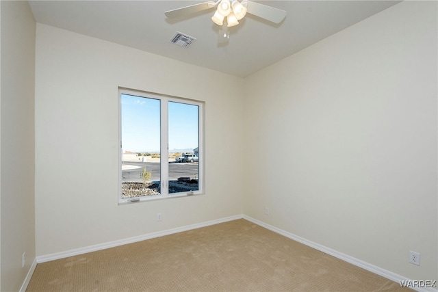 unfurnished room featuring a ceiling fan, light colored carpet, visible vents, and baseboards