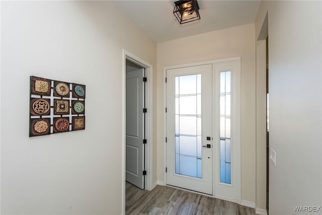 doorway to outside featuring light wood-style floors, baseboards, and french doors