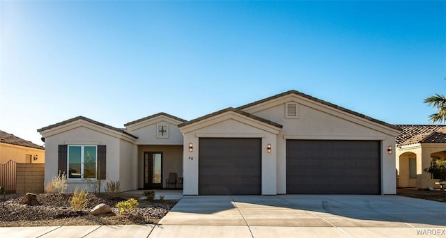 ranch-style house with an attached garage, a tiled roof, concrete driveway, and stucco siding