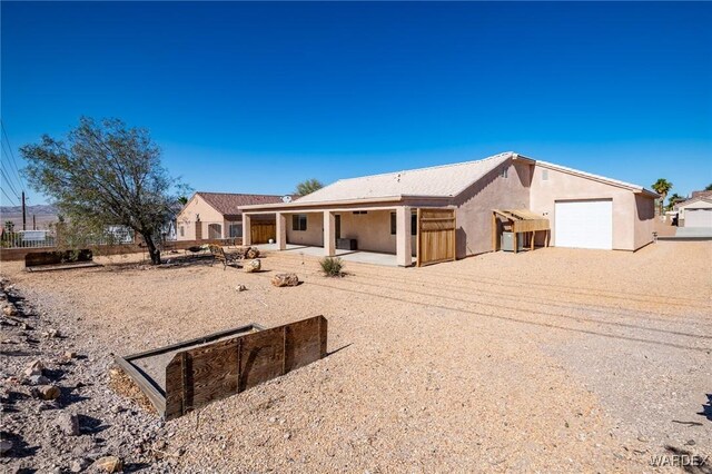 view of front facade with a garage, driveway, and stucco siding