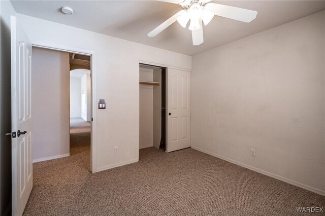 unfurnished bedroom featuring a closet, carpet flooring, a ceiling fan, and baseboards