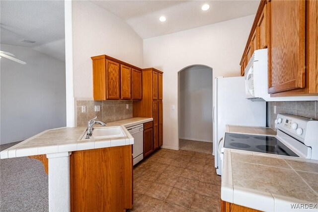 kitchen with white appliances, brown cabinets, and a sink