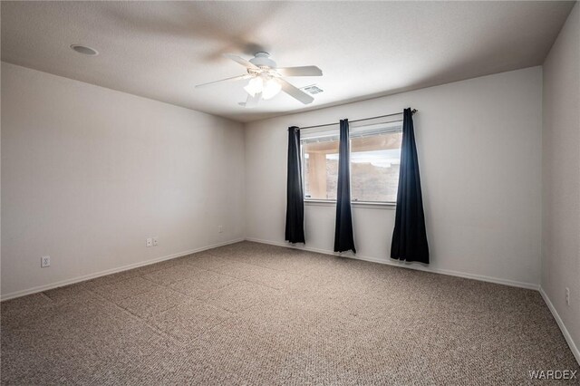 spare room featuring a ceiling fan, carpet, visible vents, and baseboards