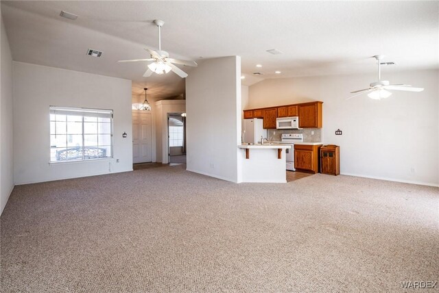 unfurnished living room featuring ceiling fan, high vaulted ceiling, visible vents, and light colored carpet