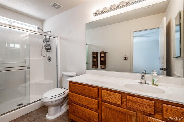 bathroom featuring visible vents, toilet, tile patterned flooring, vanity, and a shower stall