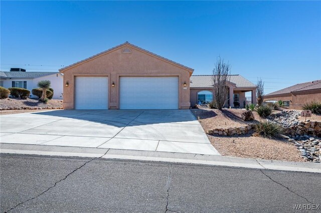 ranch-style home with driveway, a tile roof, a garage, and stucco siding