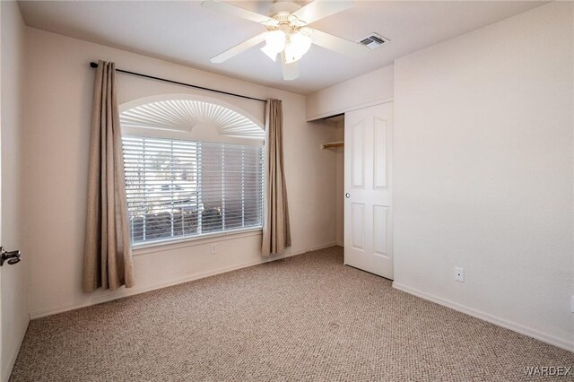 unfurnished bedroom with carpet, visible vents, ceiling fan, and a closet