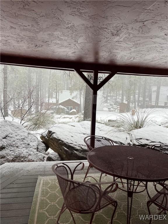 view of snow covered back of property