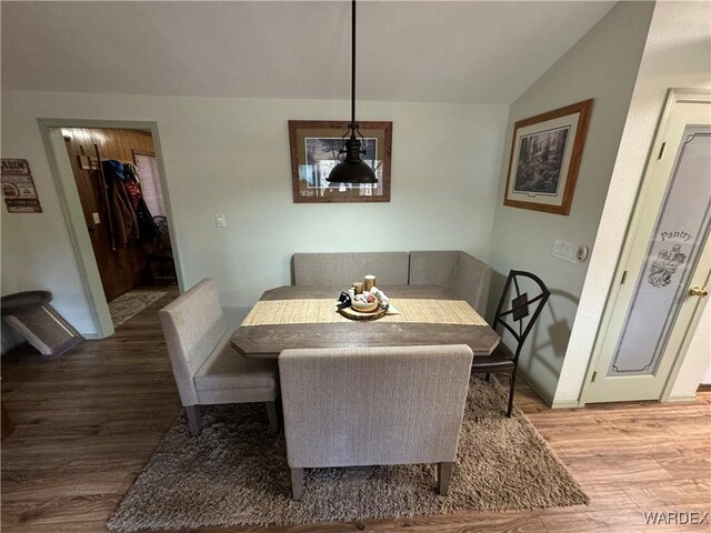 dining area with lofted ceiling, light wood-style flooring, and baseboards