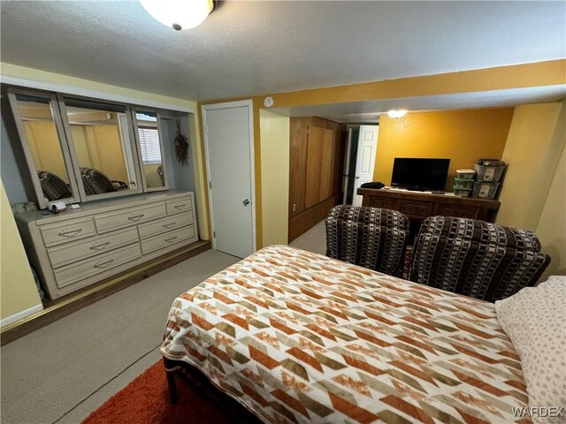 bedroom featuring a textured ceiling and light colored carpet