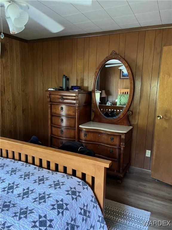 bedroom with wood walls and wood finished floors