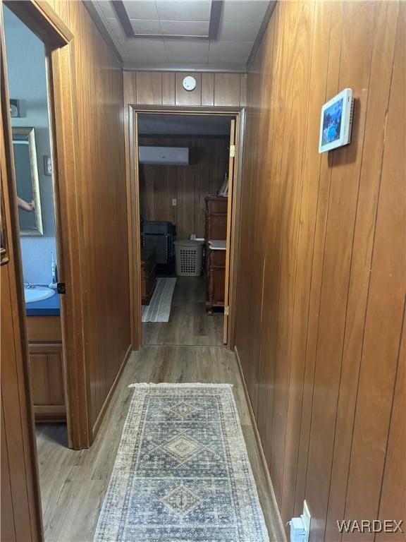 hallway featuring wooden walls and wood finished floors