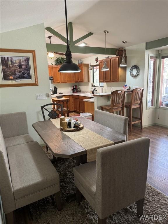 dining space featuring vaulted ceiling and wood finished floors