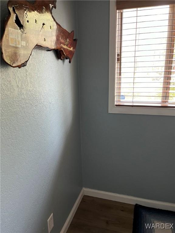 empty room featuring baseboards and wood finished floors