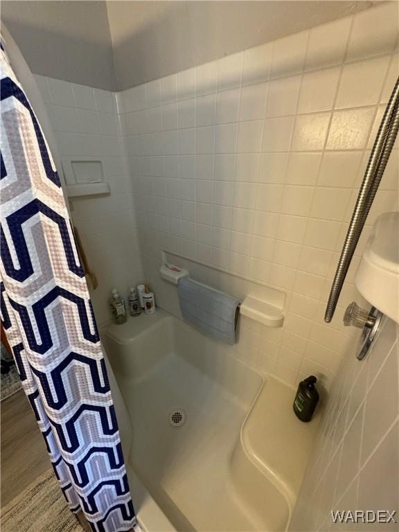 bathroom featuring a shower with shower curtain and wood finished floors