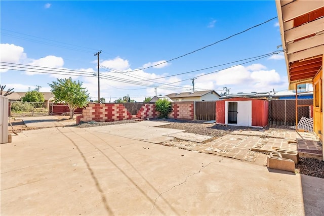view of patio / terrace with a shed, a fenced backyard, and an outdoor structure