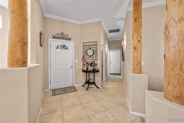 foyer with light tile patterned floors, baseboards, visible vents, and crown molding