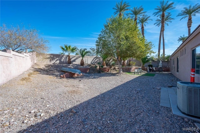 view of yard featuring central AC unit and a fenced backyard