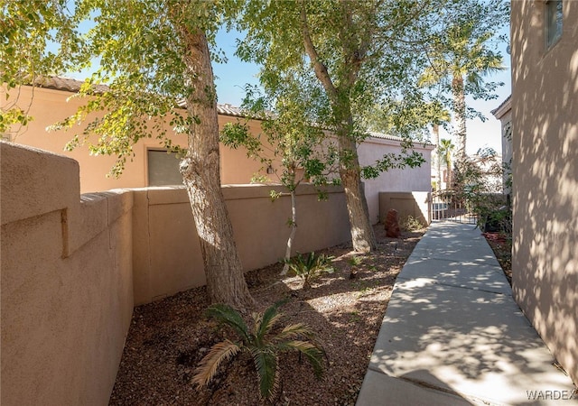 view of property exterior featuring a tile roof, fence, and stucco siding