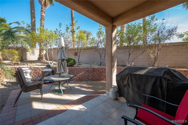 view of patio with area for grilling and a fenced backyard