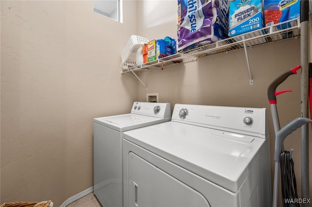 laundry area featuring laundry area, washing machine and dryer, and baseboards