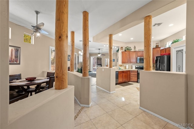 kitchen with ceiling fan, stainless steel appliances, light countertops, ornate columns, and light tile patterned flooring