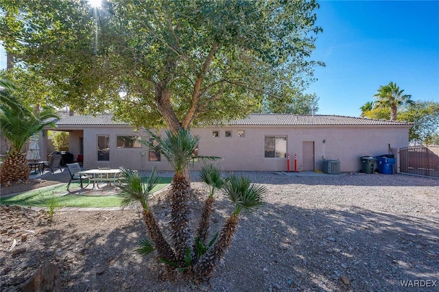 rear view of property featuring central air condition unit, a patio, a tiled roof, and stucco siding