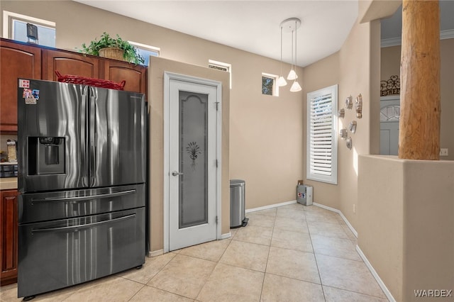 kitchen with light tile patterned floors, baseboards, decorative light fixtures, and stainless steel fridge with ice dispenser