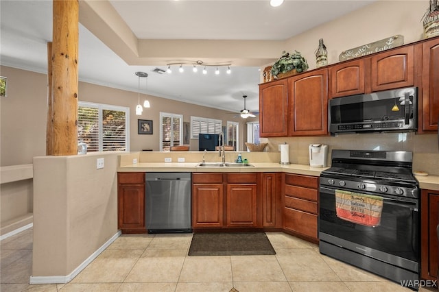 kitchen featuring appliances with stainless steel finishes, light countertops, a sink, and pendant lighting