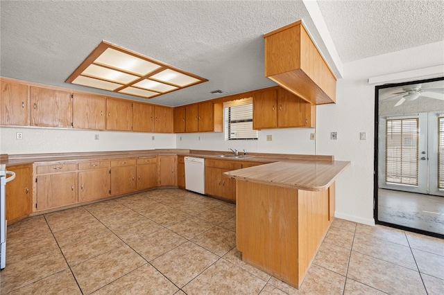 2218 Family Cir, Bullhead City, AZ 86442 - kitchen featuring dishwasher, plenty of natural light, a peninsula, a textured ceiling, and light tile patterned flooring