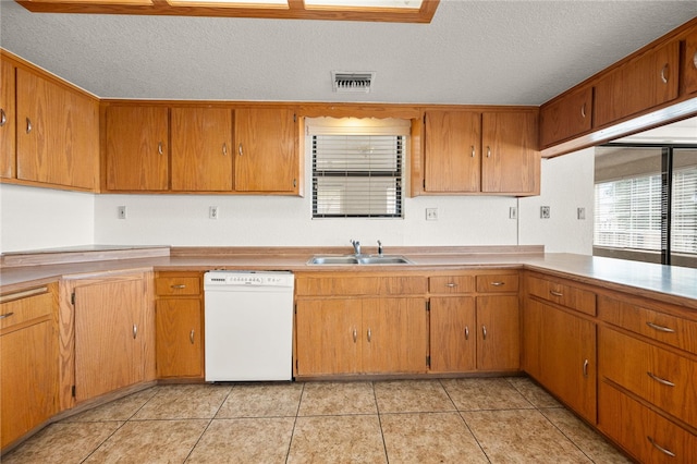 2218 Family Cir, Bullhead City, AZ 86442 - kitchen featuring dishwasher, a textured ceiling, light tile patterned floors, and brown cabinets