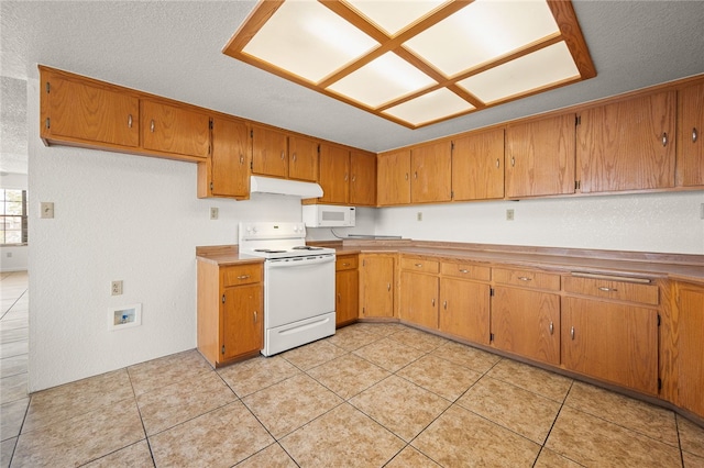 2218 Family Cir, Bullhead City, AZ 86442 - kitchen with white appliances, under cabinet range hood, brown cabinetry, light countertops, and light tile patterned floors