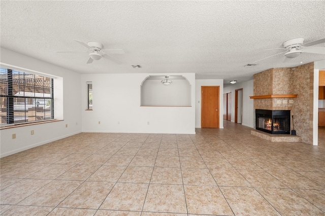 2218 Family Cir, Bullhead City, AZ 86442 - unfurnished living room with ceiling fan, a textured ceiling, a tile fireplace, and light tile patterned flooring