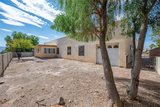 2218 Family Cir, Bullhead City, AZ 86442 - rear view of property featuring stucco siding, a fenced backyard, and a garage