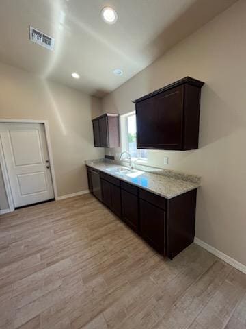 3521 E Lum Ave, Kingman, AZ 86409 - kitchen with a sink, light wood finished floors, dark brown cabinets, light countertops, and baseboards