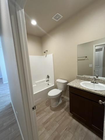 3521 E Lum Ave, Kingman, AZ 86409 - full bathroom with toilet, wood finished floors, vanity, bathtub / shower combination, and baseboards