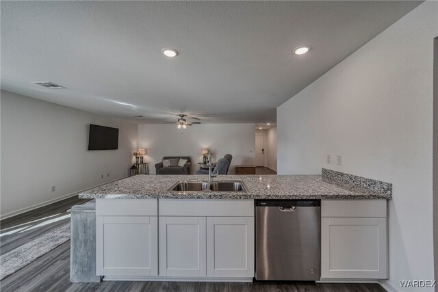 kitchen with open floor plan, stainless steel dishwasher, and white cabinets