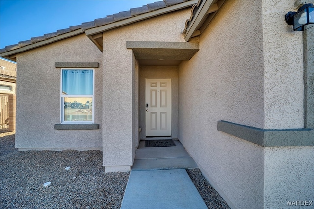 entrance to property featuring stucco siding