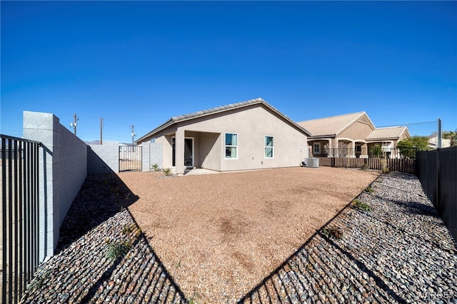 back of property with central air condition unit, stucco siding, a gate, a patio area, and a fenced backyard