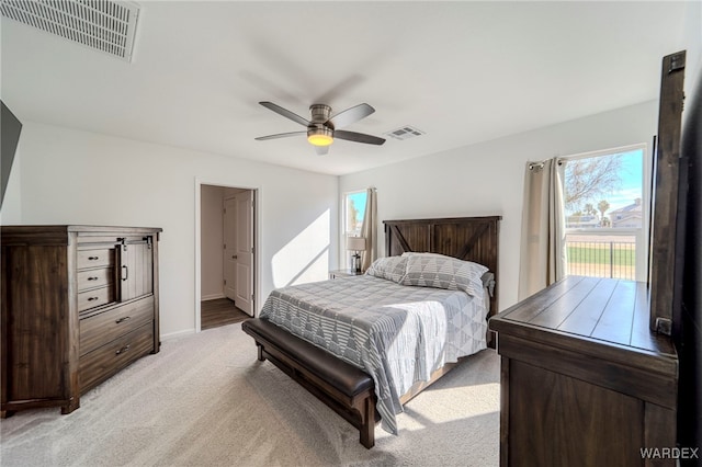 bedroom featuring a ceiling fan, light colored carpet, access to exterior, and visible vents