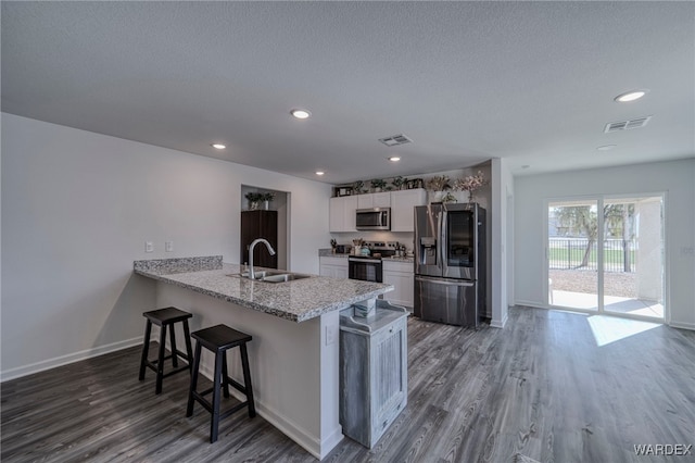 kitchen featuring white cabinetry, visible vents, appliances with stainless steel finishes, and a sink