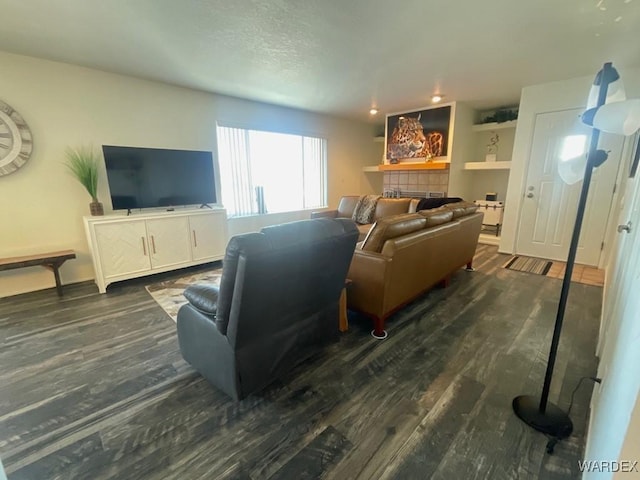 living room with dark wood-style flooring and a fireplace