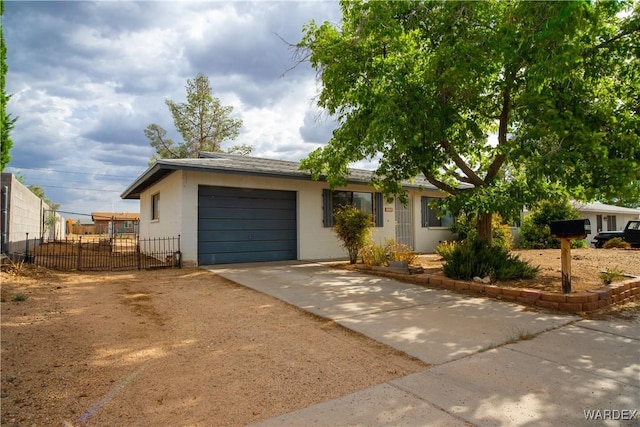 single story home with driveway, an attached garage, and fence