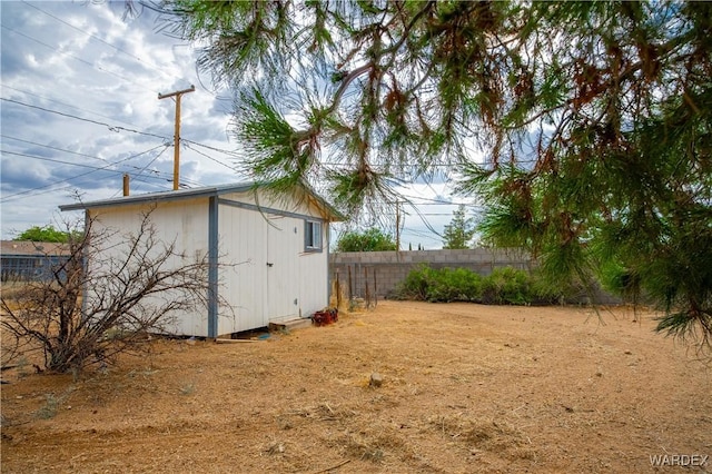 view of shed featuring fence