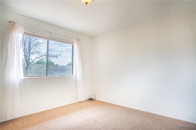 spare room with carpet floors and baseboards