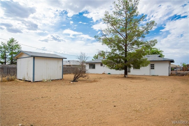 view of yard featuring an outdoor structure, a storage shed, and fence