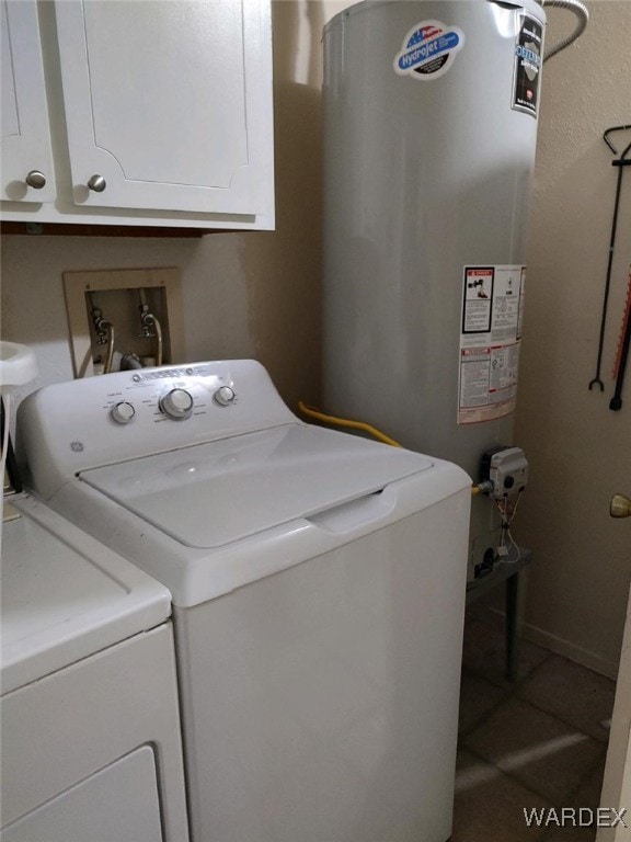 laundry area featuring tile patterned flooring, baseboards, gas water heater, and washing machine and clothes dryer