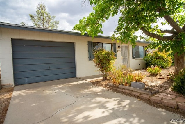 ranch-style home with a garage and concrete driveway