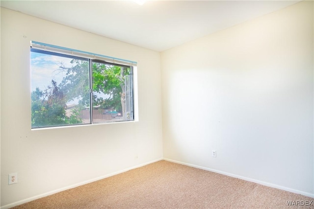 carpeted spare room featuring baseboards