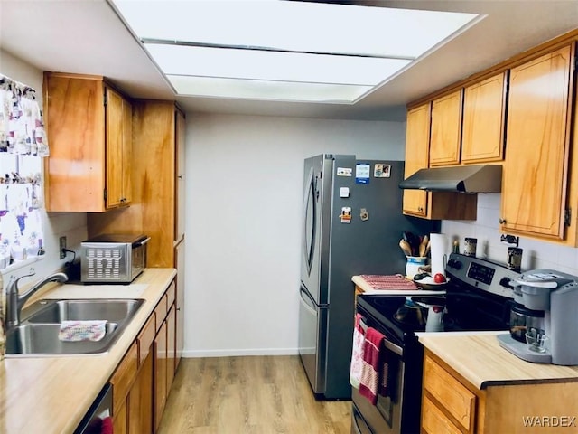 kitchen with under cabinet range hood, stainless steel appliances, a sink, light countertops, and brown cabinetry